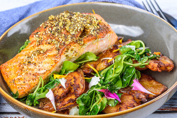 Grilled salmon served with crispy chat potatoes, snow pea tendrils and dukkah butter