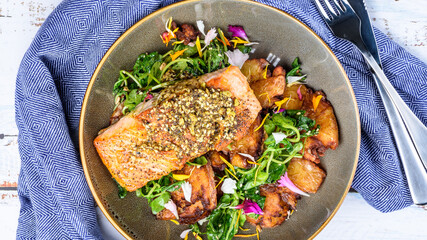 Grilled salmon served with crispy chat potatoes, snow pea tendrils and dukkah butter