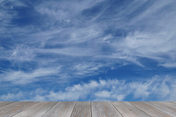 grey wooden aged table top with spindrift clouds background