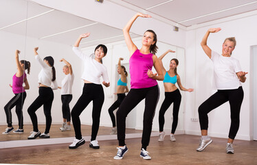 Fototapeta na wymiar Women dancing aerobics at lesson in the dance class. High quality photo
