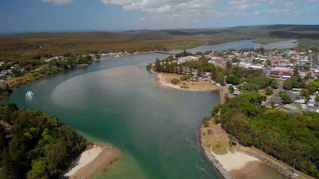 Aerial view over the river at the Evans Head village, sunny day - reverse, drone shot