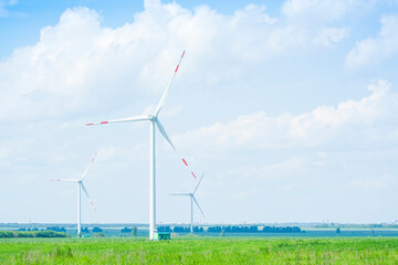 many windmills stand on a large field