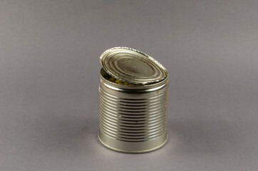 Open tin can on a gray background.