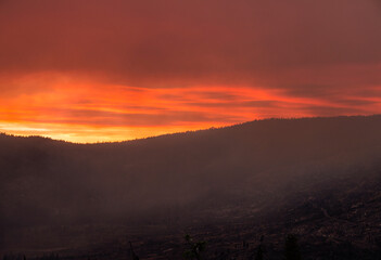 Naklejka na ściany i meble red fiery sky and dark clouds cover the summer Yosemite sky due to a forest fire.