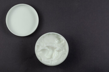 Cosmetic cream container on gray background.