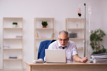 Fototapeta premium Old male employee in blood transfusion concept