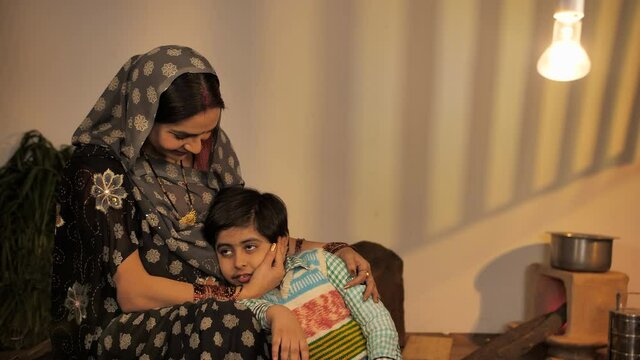 Little son hugging his pregnant mother's belly with love and smile - new life concept. Loving village expecting mother and her cute boy spending quality time together during evening time - maternit...