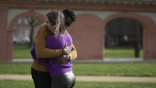 Interracial couple empathic embrace. Young woman romantic connection with partner outside