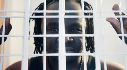 Portrait of african american black man holding bars in the prison. High quality photo