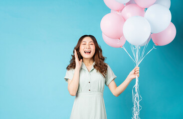 Young Asian girl holding balloons with happy expression on background