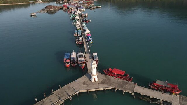 Fast orbit shot above the lighthouse on Bang Bao pier in Koh Chang, Thailand.