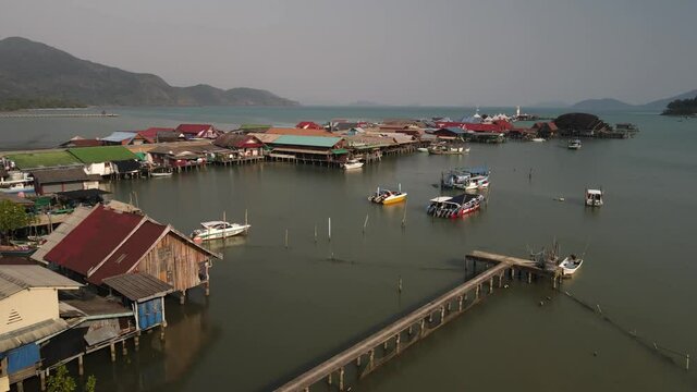 Fast aerial pan to the right of the Bang Bao fishing pier in Koh Chang, Thailand.