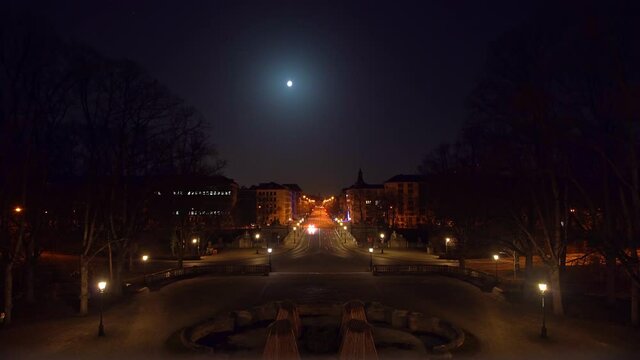 Lonely long street in Munich in times of Corona and the Covid-19 lockdown under the shining full moon with the view at the cityscape of the bavarian popular city, nearly empty at night.