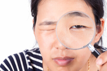A girl with a magnifying glass and eyes closed