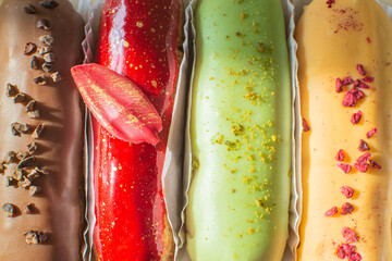 Eclairs chocolate, raspberry, pistachio and lemon close-up. Hello sweet mood. Concept baking, cookbook recipes, bakery banner, cafe advertisement. Vacation sales summer and holiday.