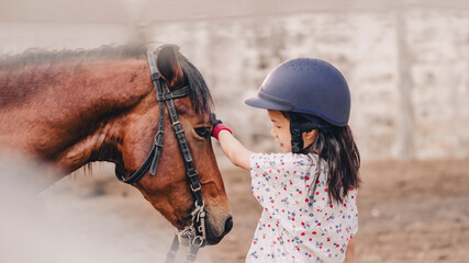 Asian school kid girl with horse ,riding or practicing horse ridding at horse ranch