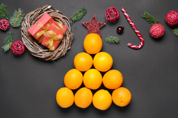 Christmas tree made of oranges and decorations on dark background