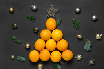 Fototapeta na wymiar Christmas tree made of oranges and decorations on dark background