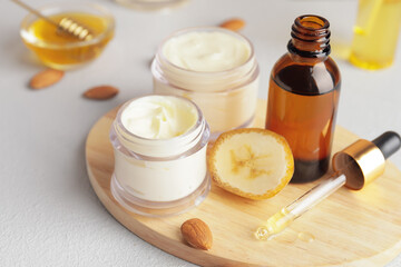 Composition with banana cosmetics on light background, closeup