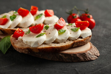 Ciabatta with cherry tomato, basil, mozzarella and spices. Bruschetta with cheese on concrete table. 