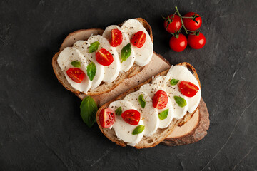 Ciabatta with cherry tomato, basil, mozzarella and spices. Bruschetta with cheese on concrete table. 