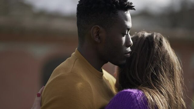Interracial couple empathic embrace. Young woman romantic connection with partner outside