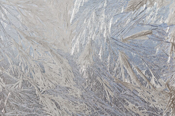 Winter snowy frosty patterns on the glass window. Winter magic. Frosty wonders. Abstract patterns.