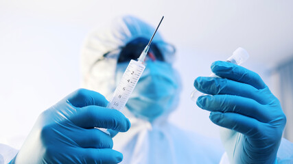 Vaccination and immunization against covid-19. Doctor in full uniform preparing vaccine. High quality photo