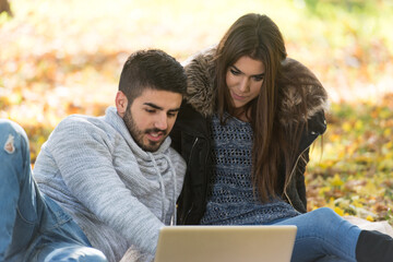 Young Couple Using Laptop At Outdoor In Park