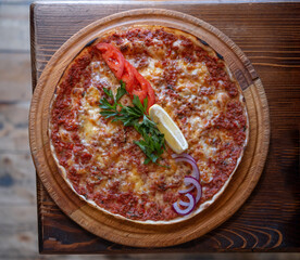 traditional oriental dish lahmajun (lahmacun) of Turkish, Arabic and Armenian cuisine. arabic pizza with meat, cheese, tomatoes, lemon and herbs, top view