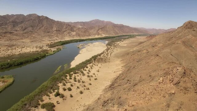 Fish river streambed navigating arid natural gorge in Namibia, Africa - Aerial wide fly-over shot