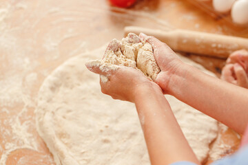 Close up of woman with her child kneading dough