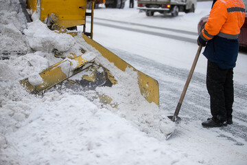 Snow plow and snow truck cleaning the streets during a snow storm in night maintenance action in...
