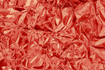 Shiny red foil texture background, pattern of wrapping paper with crumpled and wavy.