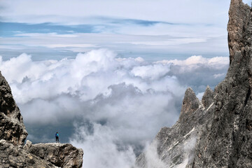 Woman on cliff above the clouds.  Dolomites. Italy. 