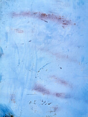 texture of old painted rusty blue wall or garage door with peeling and cracked paint and corrosion