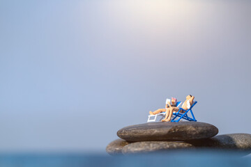 Fototapeta na wymiar Miniature people sunbathing on The beach , Summer time concept