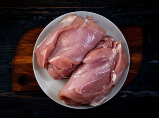 raw meat pieces in plate on wooden table