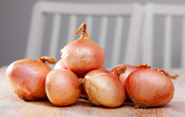 Image of onion bulbs on wooden background, nobody