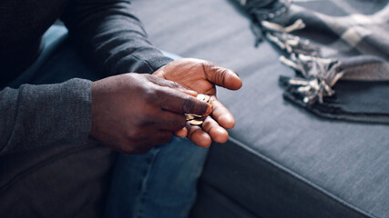 Black man counting coins. Close up on the hands of poor man . High quality photo