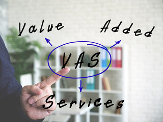  VAS Value Added Services note. Businessman hand point finger on an background.