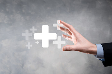 Businessman, man hold in hand offer positive thing such as profit, benefits, development, CSR represented by plus sign.The hand shows the plus sign