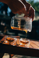 Pouring black tea, female hand holding a teapot