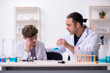 Fototapeta premium Young father and son chemists in the lab