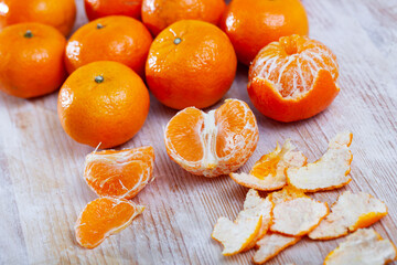 Fresh whole and sectioned clementines on wooden background. Vitamin cooking ingredients © JackF