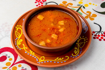 Ukrainian and russian national food - red beet borscht served in a ceramic plate over traditional Ukrainian tablecloth