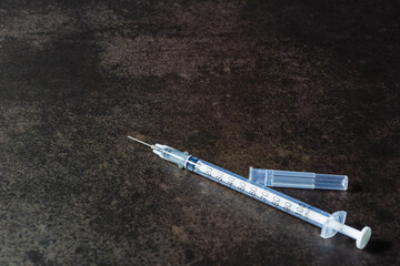 New syringe on dark table background.