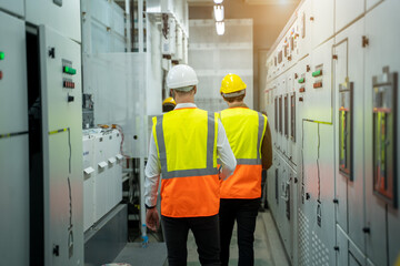 Technical worker with engineer working and checking in control room power plant at industry factory.