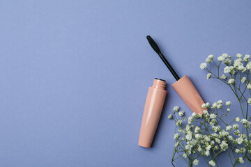 Mascara and gypsophila flowers on violet background