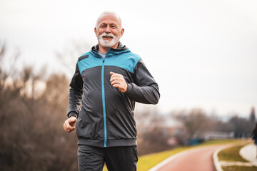 Active senior man is jogging. Healthy retirement lifestyle. - Powered by Adobe